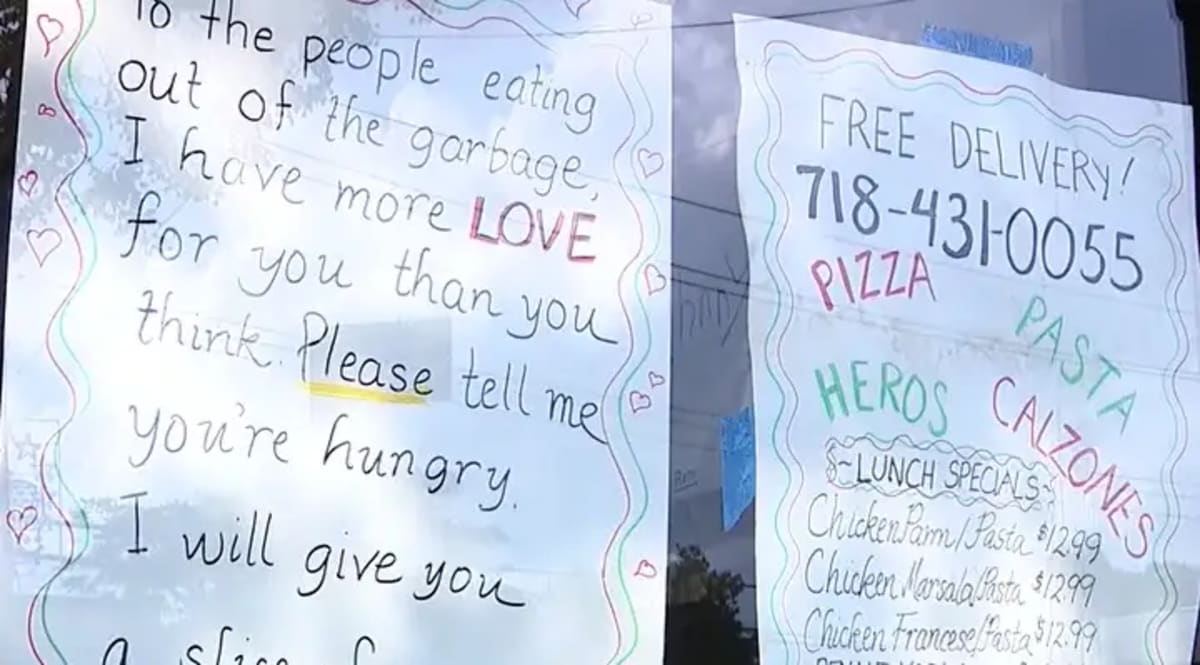 Handwritten sign at Bronx pizzeria offering free slices to anyone who is hungry