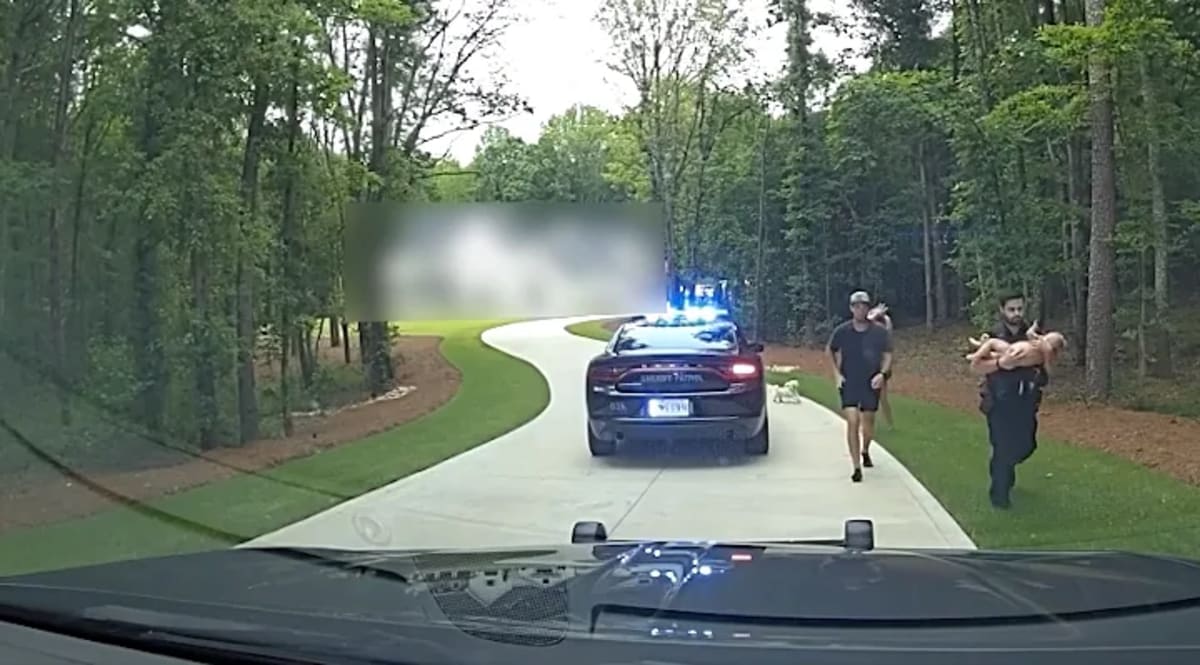 Two Greenville County sheriff's deputies performing emergency rescue on young child after pool accident