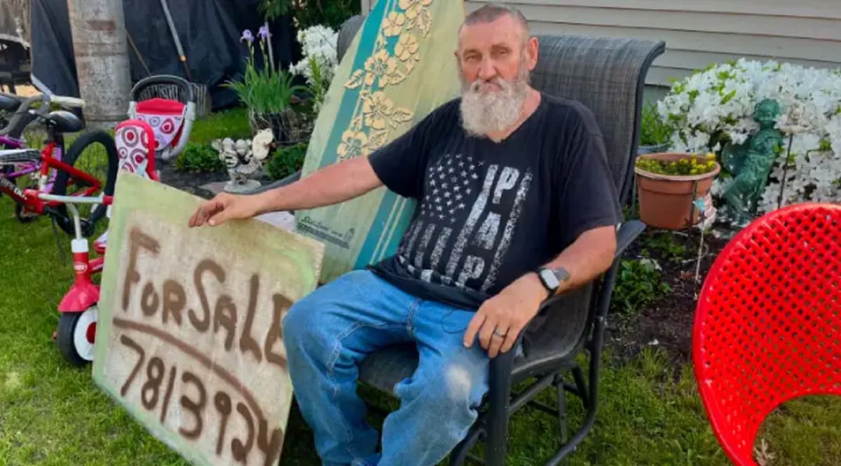 Jack Burnett stands beside refurbished bicycles and furniture on his Warwick Rhode Island front lawn