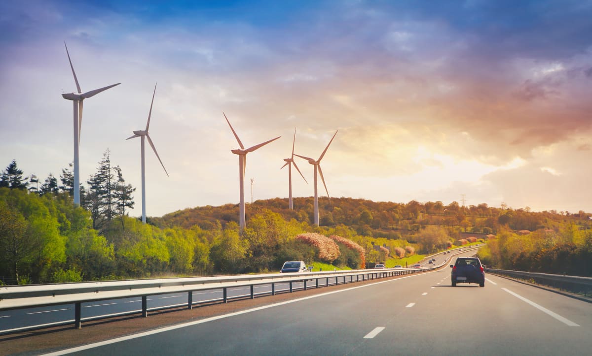 ** Solar panels and wind turbines stretching across American landscape with battery storage facilities