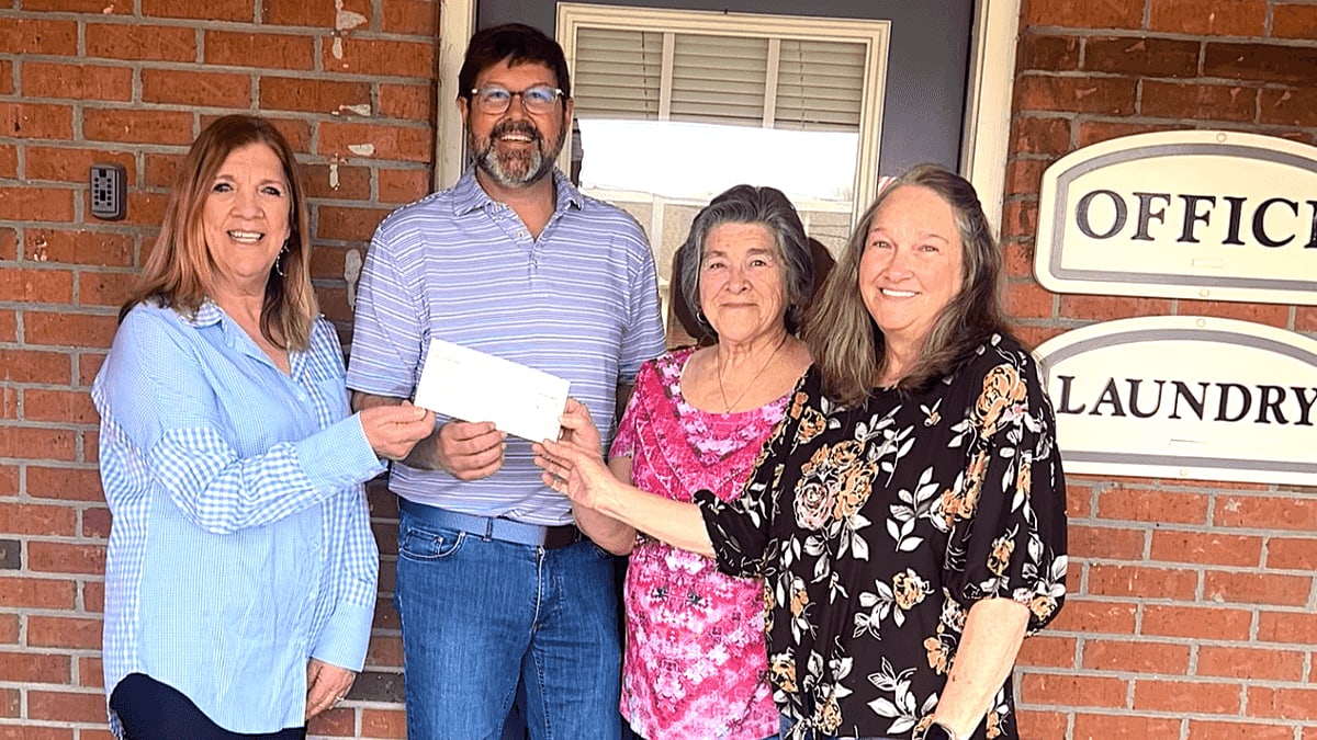 ** Four Meadowcrest Apartments residents standing together encouraging donations to CARH Scholarship fund in Luverne Alabama