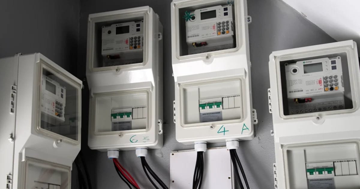Customer checking prepaid electricity meter mounted on wall in Lagos, Nigeria home