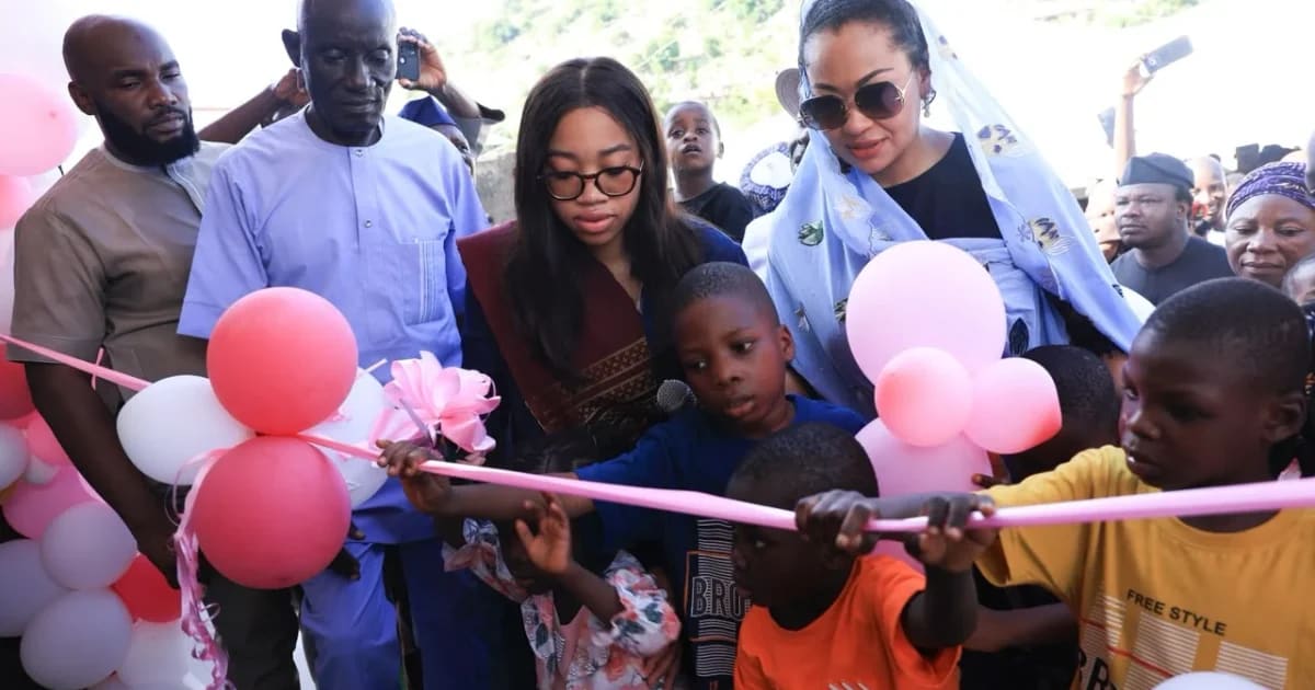 Teen girl Nadia Zakaria standing with community members and orphanage founder at building opening ceremony