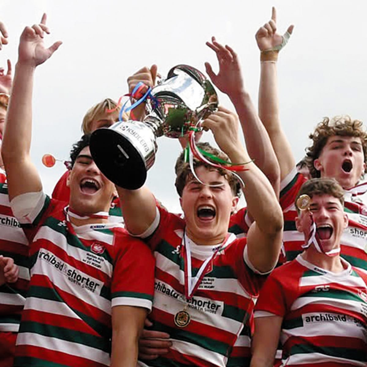 Westlake Boys High School rugby players celebrating their championship victory on the field with supporters