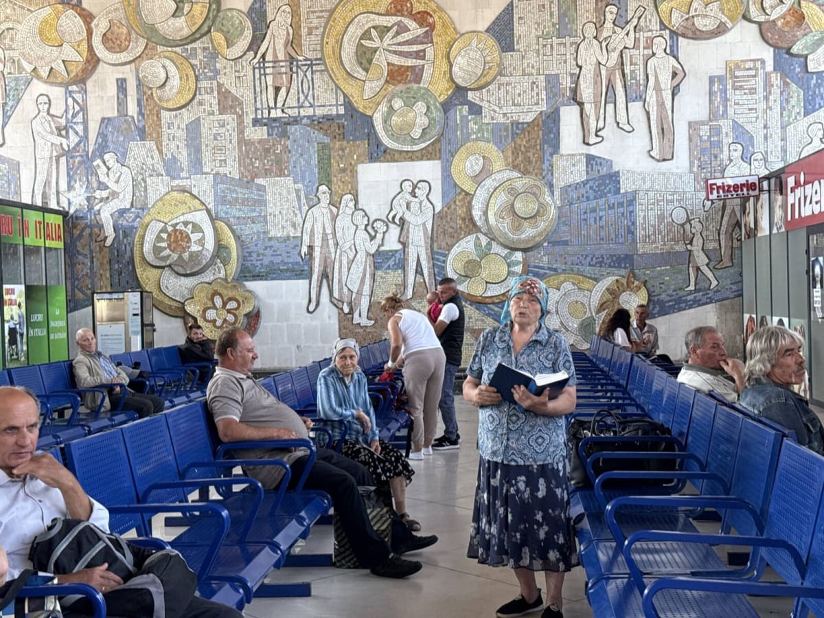 Colorful Soviet-era mosaic with red, yellow, and blue fragments depicting workers and urban scenes