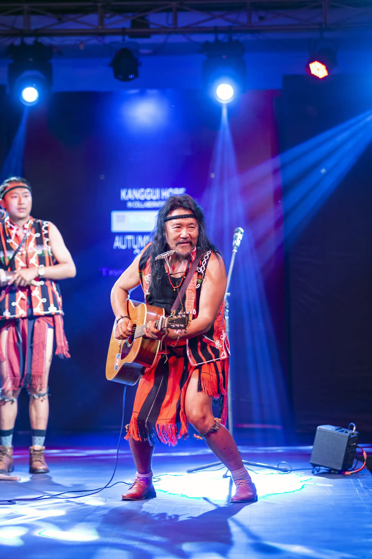 Rewben Mashangva and son Saka perform on stage in traditional Tangkhul Naga red and black clothing