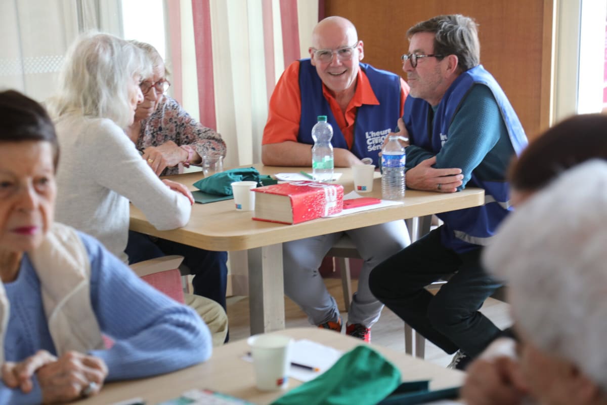 Elderly residents playing Scrabble with community volunteers at Paris nursing home