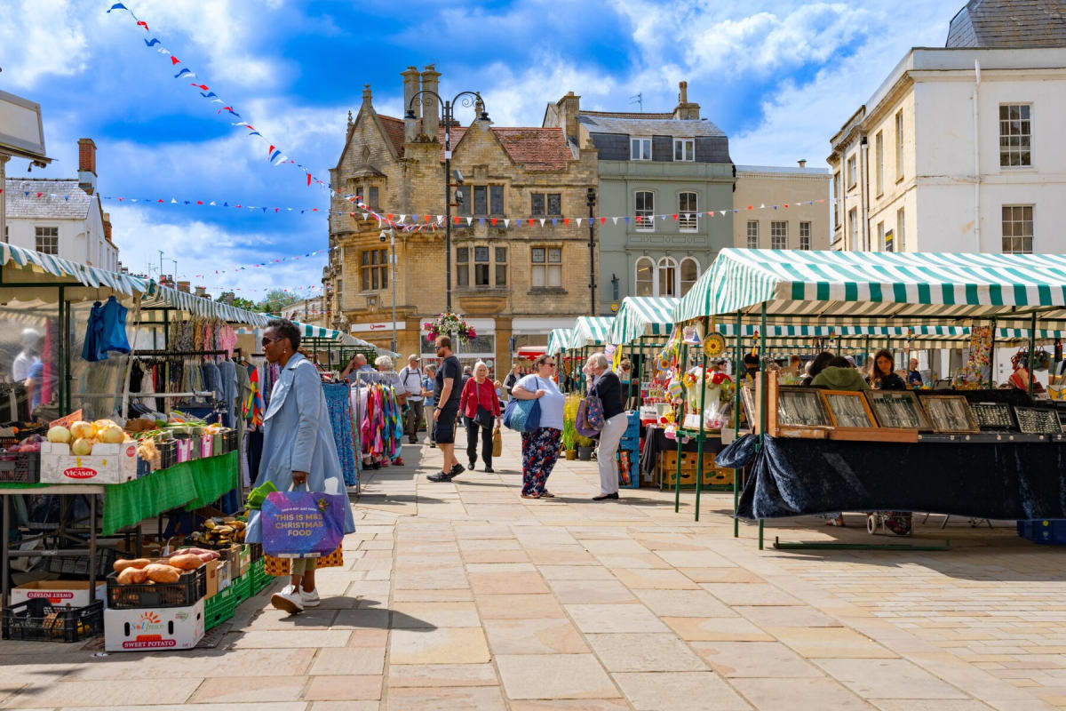 ** Young vendor selling creative products at a colorful British street market stall
