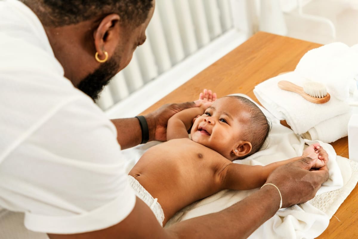 Father holding and bonding with newborn baby at home during parental leave