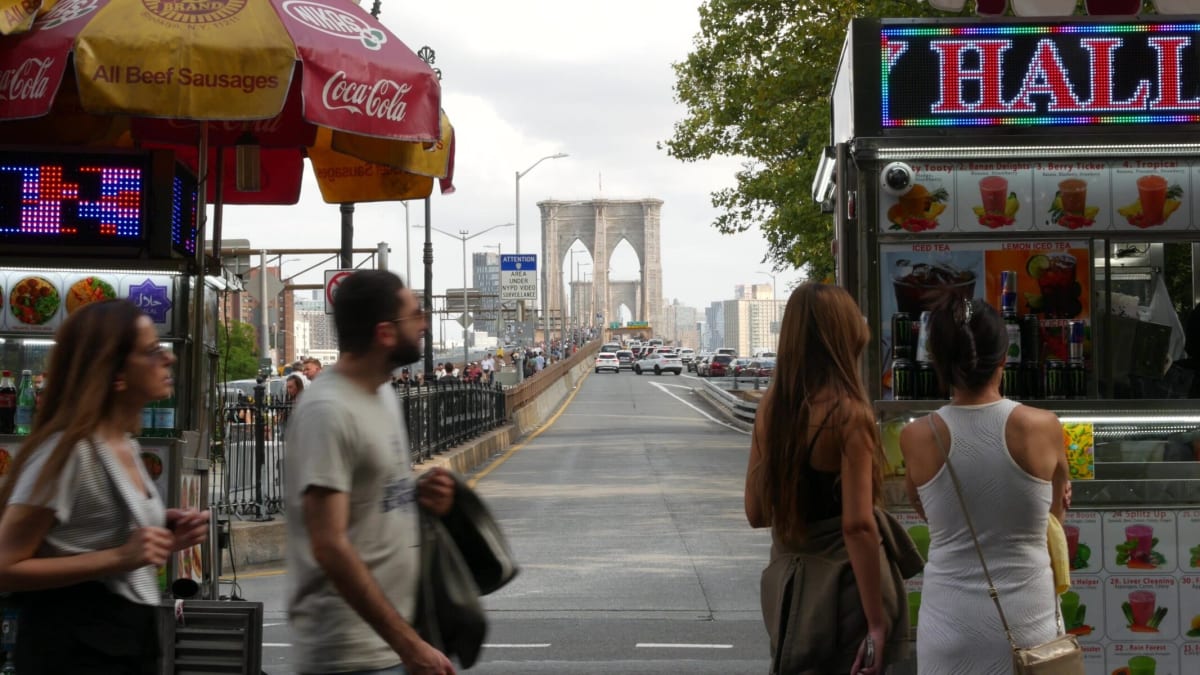 Person wearing headphones walks through busy New York City street listening mindfully