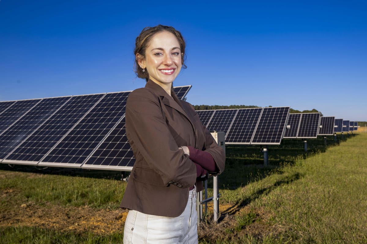 UNC student Victoria Farella standing outdoors on campus, environmental science major researching renewable energy solutions