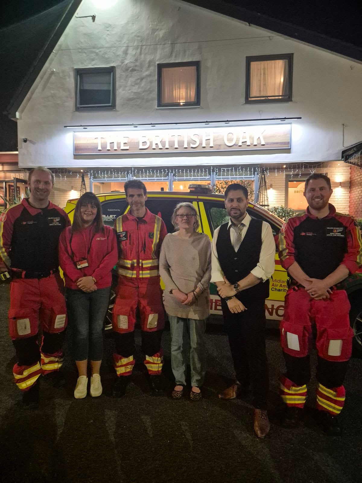 Shaz Saleem standing with quiz night participants and raffle winners at charity fundraiser event