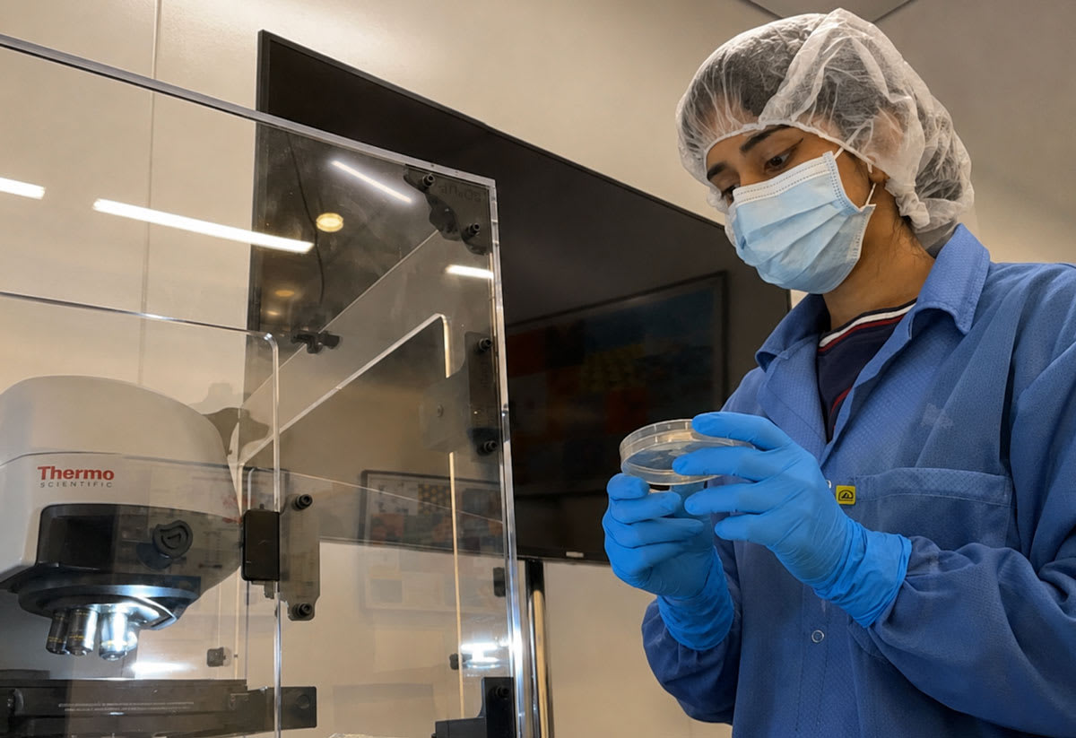 Young scientist working in laboratory examining research materials and taking notes