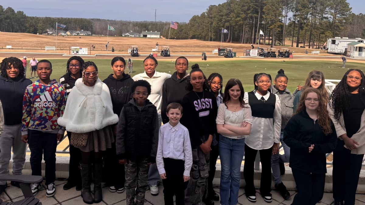 Sixth grade students presenting business pitch to panel of judges at golf club