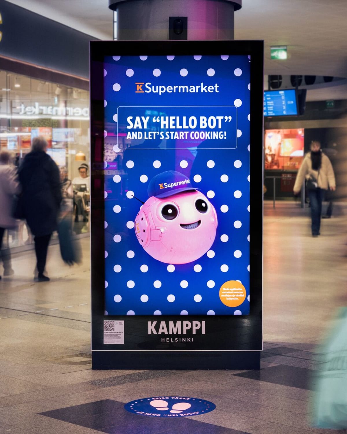 Animated digital display character on shopping mall screen interacting with shoppers in Finland