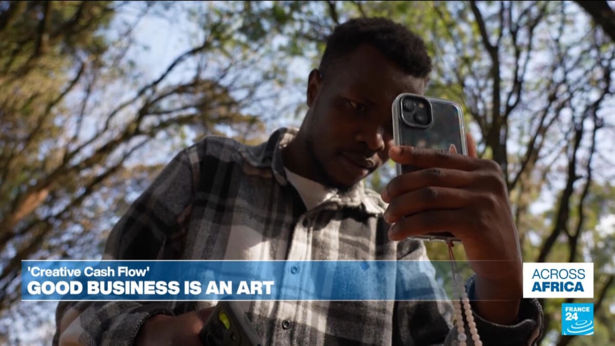 Marie Lora-Mungai holding her book Creative Cash Flow for African artists and creatives