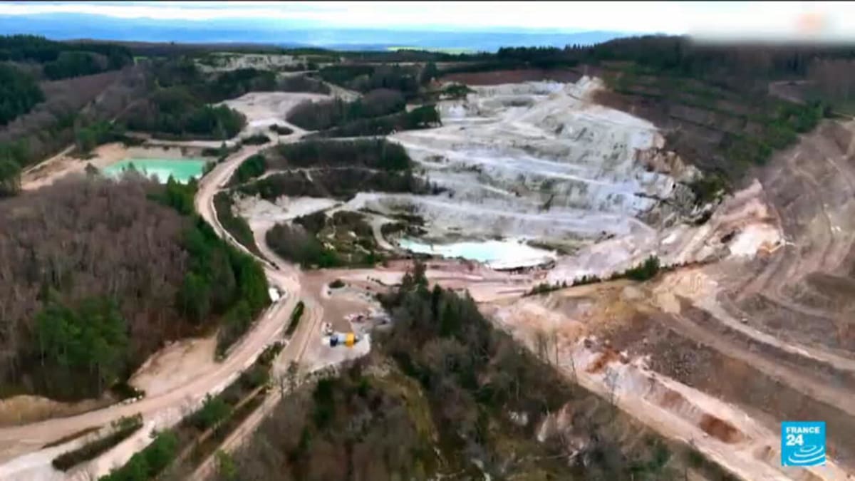 ** President Emmanuel Macron touring lithium mining facility with industrial equipment in central France