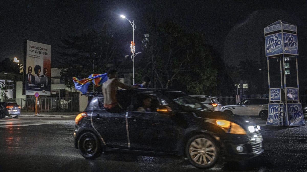 Jubilant football fans celebrating in city streets waving national flags after World Cup qualification announcement