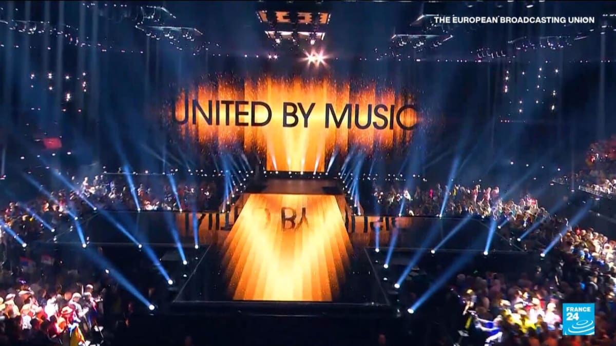 Colorful stage lights and performers representing Eurovision Song Contest's expansion to Asia