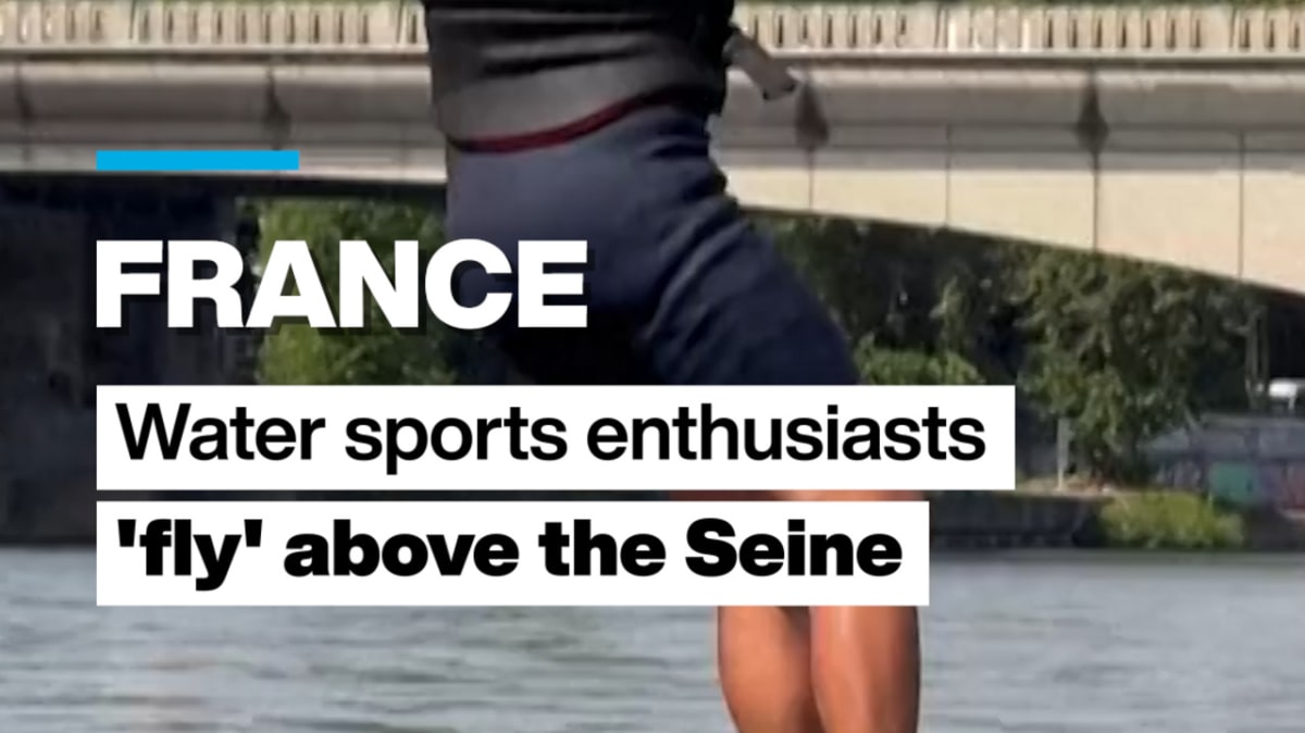 Person riding electric hydrofoil board above water on Seine River in Paris