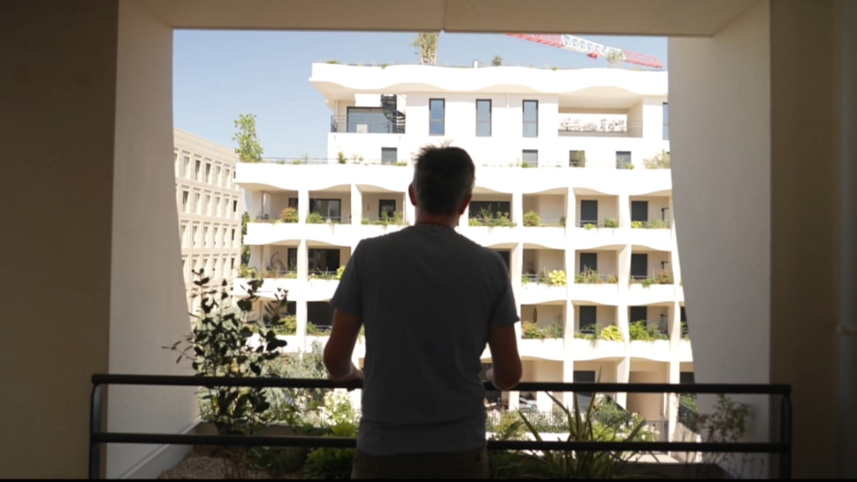 Modern curved apartment building in Montpellier with decorative lattice screens designed for natural cooling