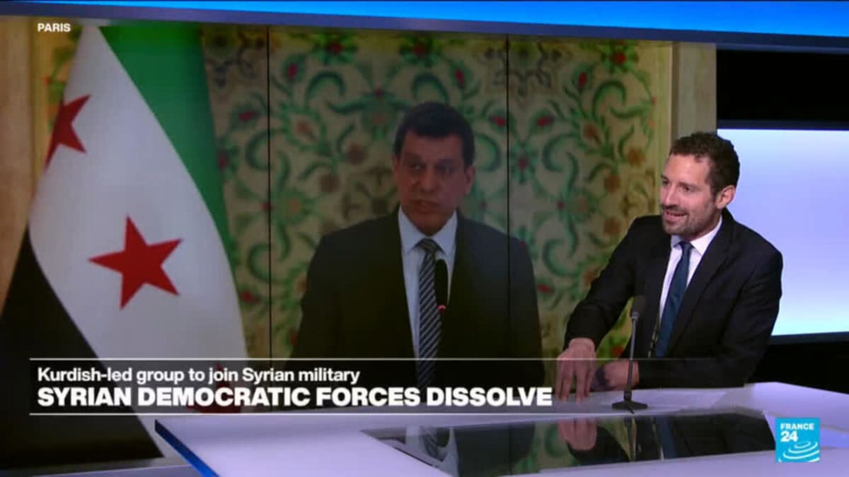 ** Kurdish and Syrian officials shake hands during historic integration ceremony in Syria