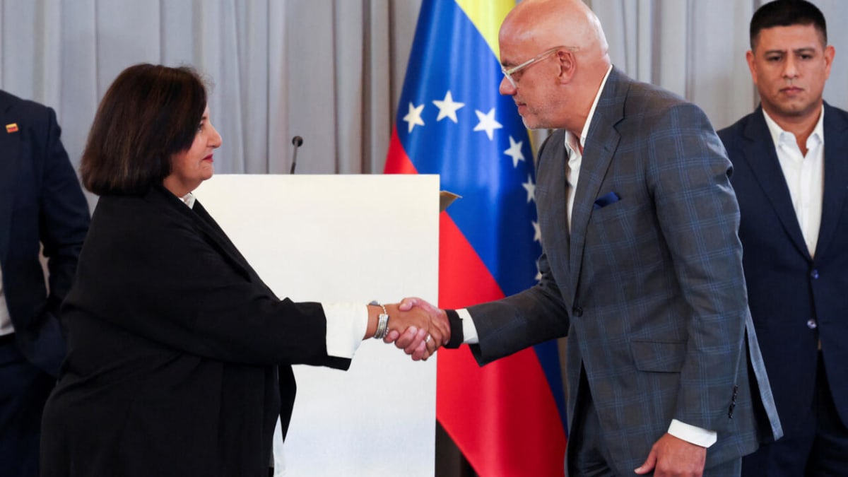 Venezuelan government and opposition representatives shaking hands during reconciliation talks in Caracas