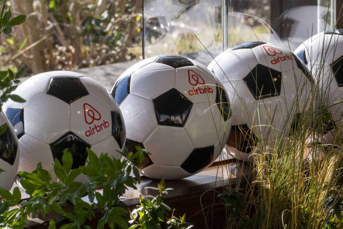 Soccer balls with Airbnb logos displayed at Houston press conference for world record attempt announcement