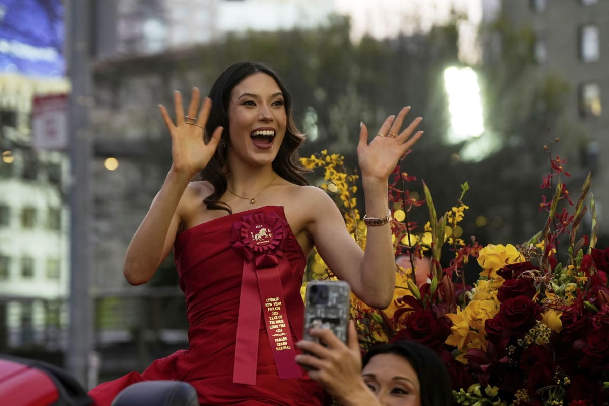 Olympic gold medalist Eileen Gu waves and smiles from red convertible during San Francisco parade