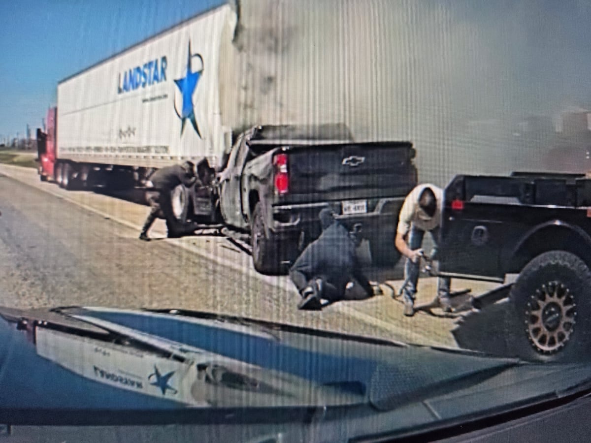 Damaged pickup truck wedged under semi-trailer on Interstate 10 as bystanders attempt rescue