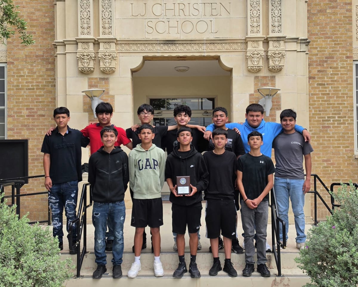 Twelve seventh grade boys from Christen Middle School track team posing with championship trophy