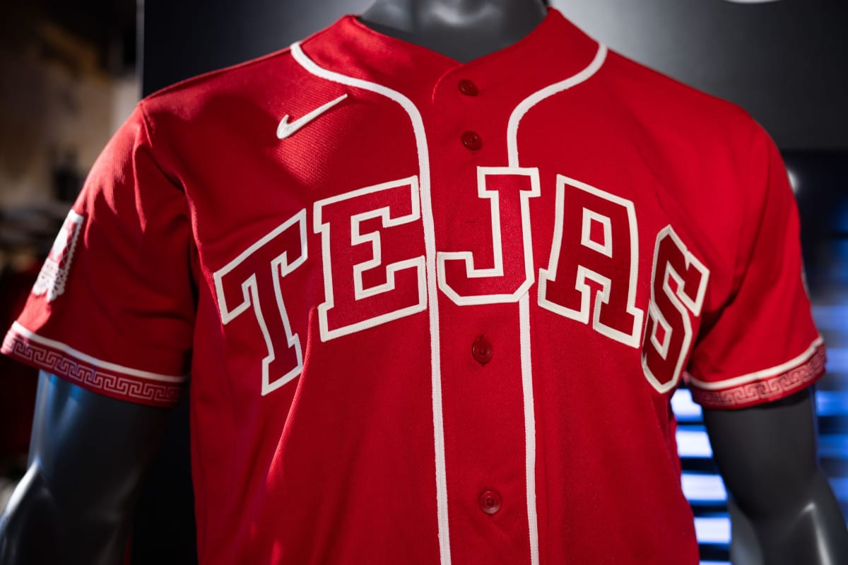 Red Texas Rangers jersey displaying TEJAS in white letters with ornate cultural details