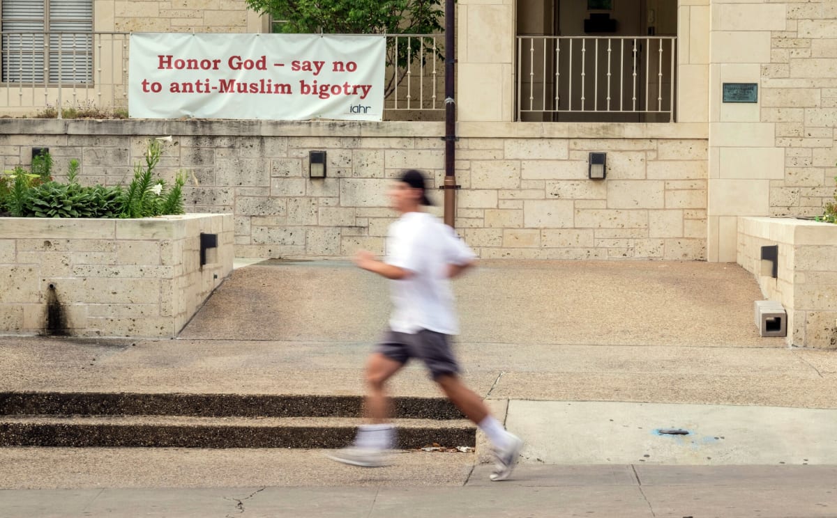 Runner passing anti-Islamophobia sign in Austin, Texas promoting religious tolerance and understanding