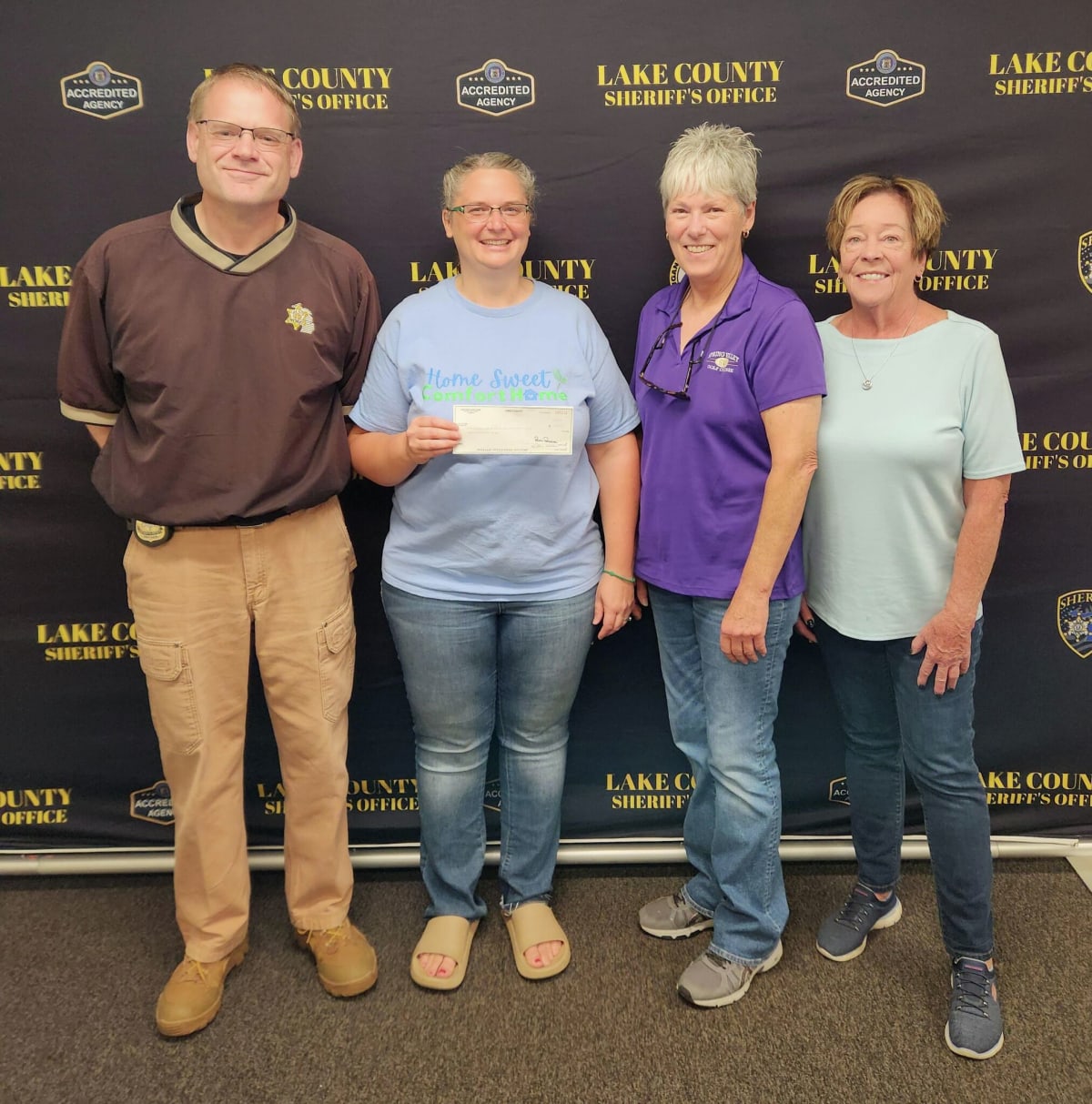 Sheriff Rich Martin presenting oversized check to Comfort Home nonprofit representatives in Lake County
