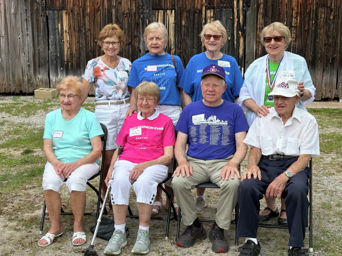 Eight elderly Bartos siblings posing together at family farm reunion in Michigan