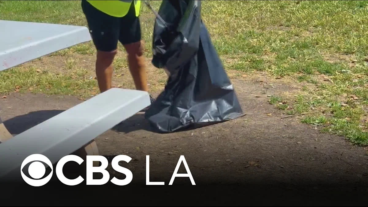 ** Volunteers in safety vests cleaning up Inglewood streets in preparation for World Cup
