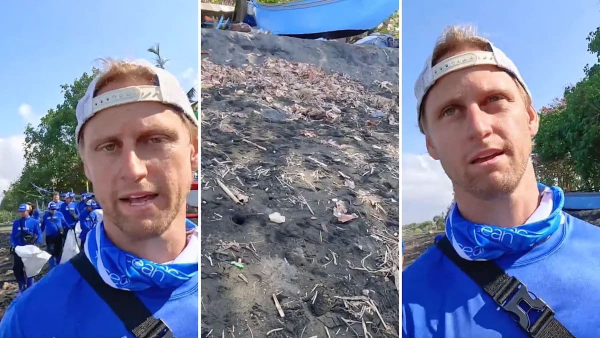 Ocean cleanup crew member collecting large plastic bottles and containers from sandy beach