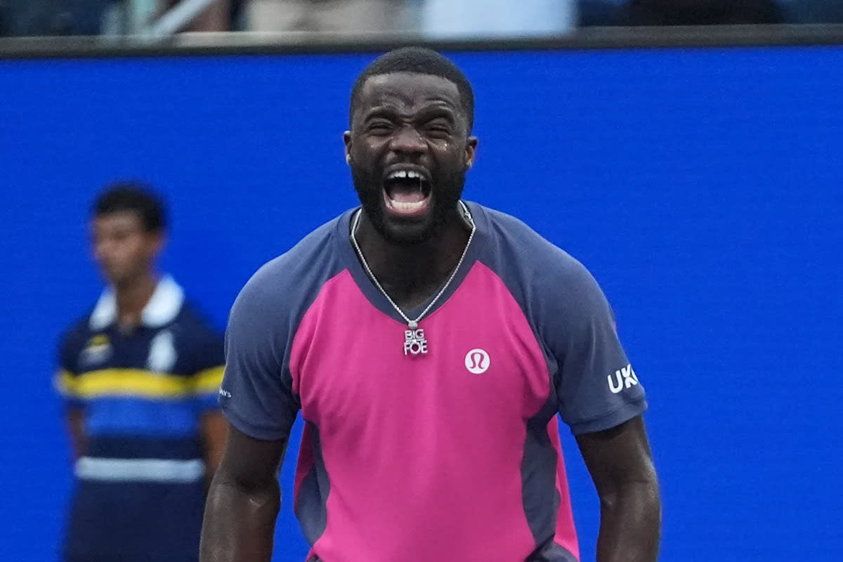 Frances Tiafoe celebrating on tennis court at US Open in front of cheering crowd