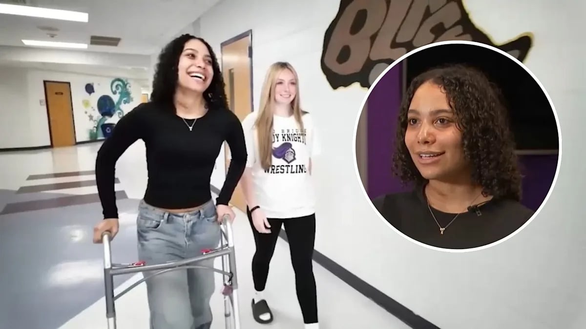 High school wrestler Adriana Maria walking with walker in school hallway smiling
