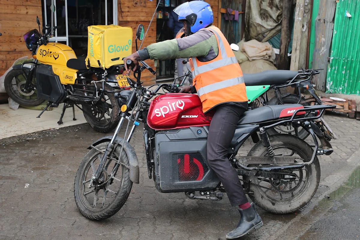 Rider on electric Spiro motorcycle at battery-swapping station in Nairobi, Kenya