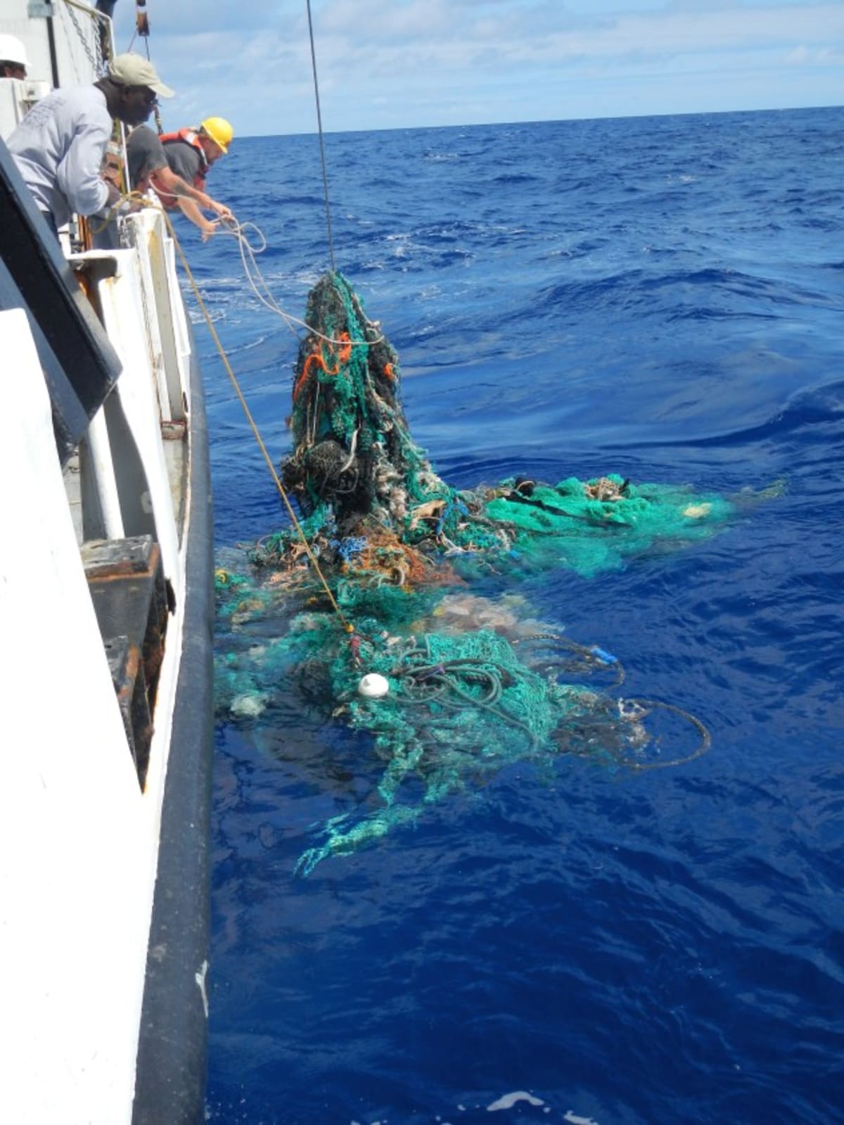 Crew members pulling abandoned fishing nets from the Great Pacific Garbage Patch between Hawaii and California