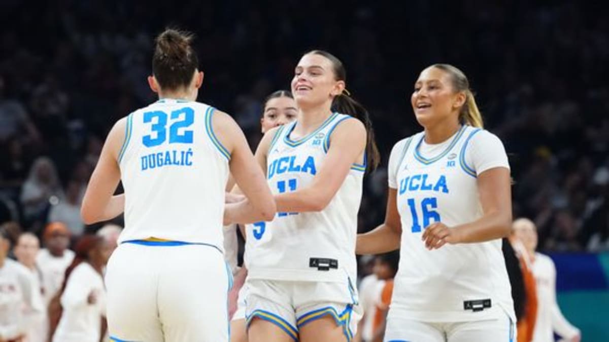 UCLA women's basketball players celebrating together during their NCAA semifinal victory in Phoenix