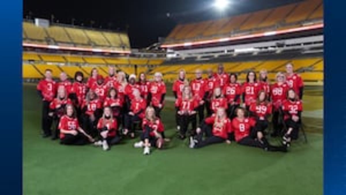 Damar Hamlin in Buffalo Bills uniform smiling alongside American Heart Association representatives at CPR training event