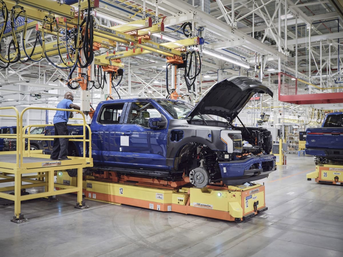 Camouflaged Ford electric pickup truck prototype on road during testing phase
