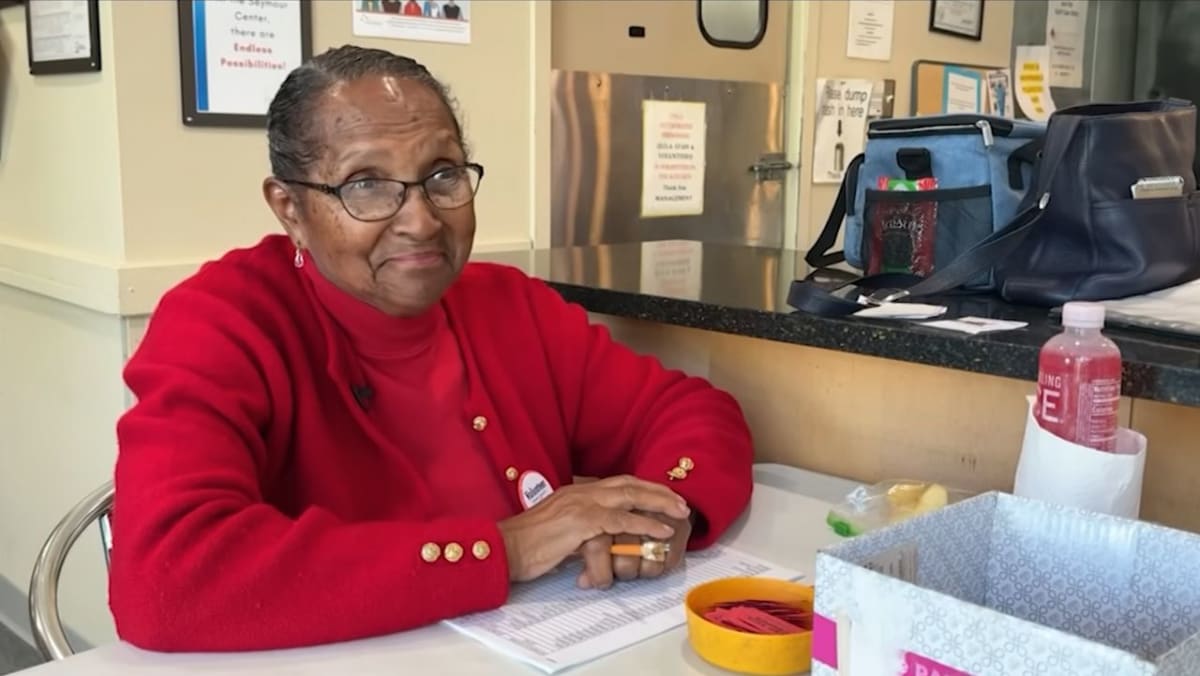 Smiling 90-year-old woman Juliaette Reynolds greeting seniors at Chapel Hill community center