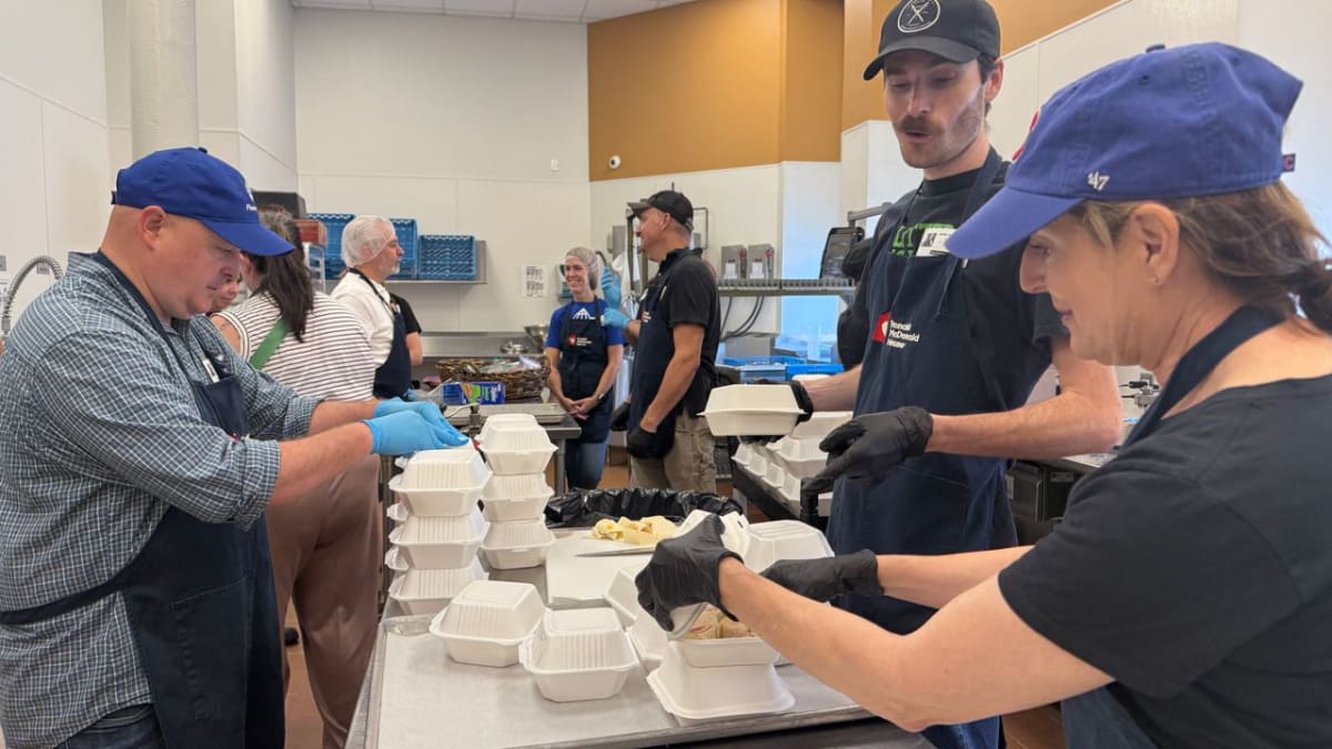 Volunteers preparing meals together at a community kitchen for families facing food insecurity