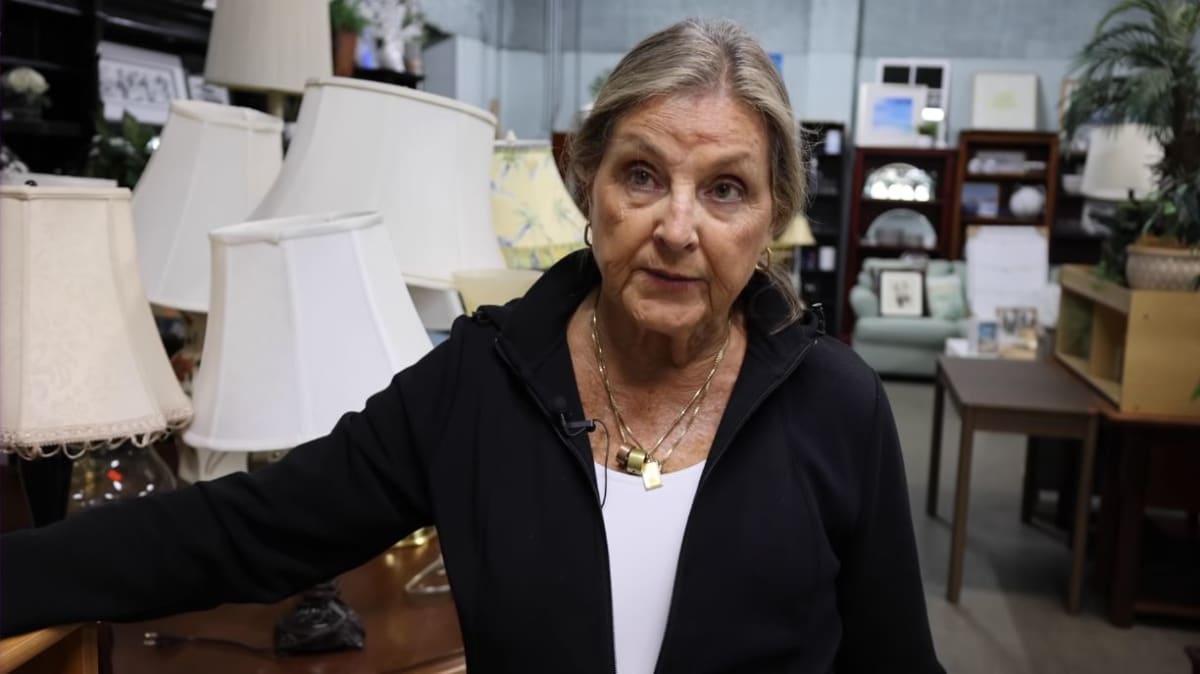 Volunteer organizing donated furniture and household items inside Orlando nonprofit thrift store