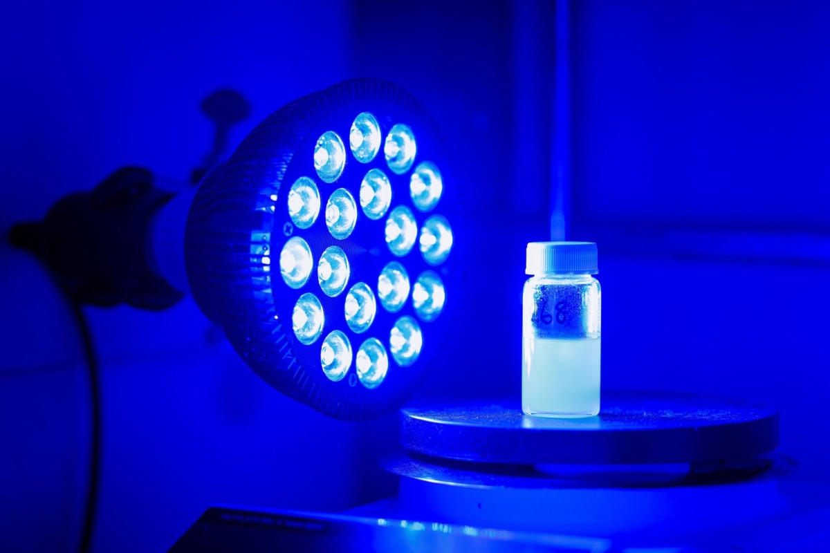 Blue LED lights illuminating glass vials in laboratory Buffalo boxes used for drug molecule research