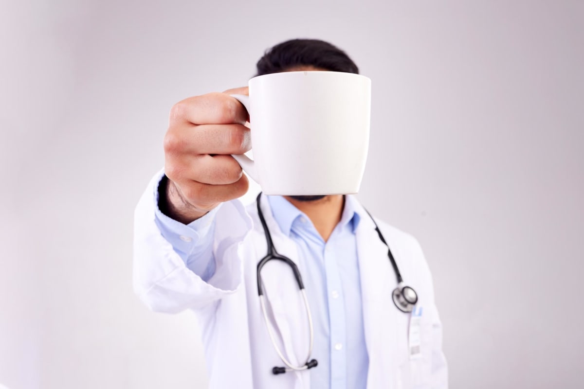 Steaming cup of coffee on table with gut and brain connection illustration