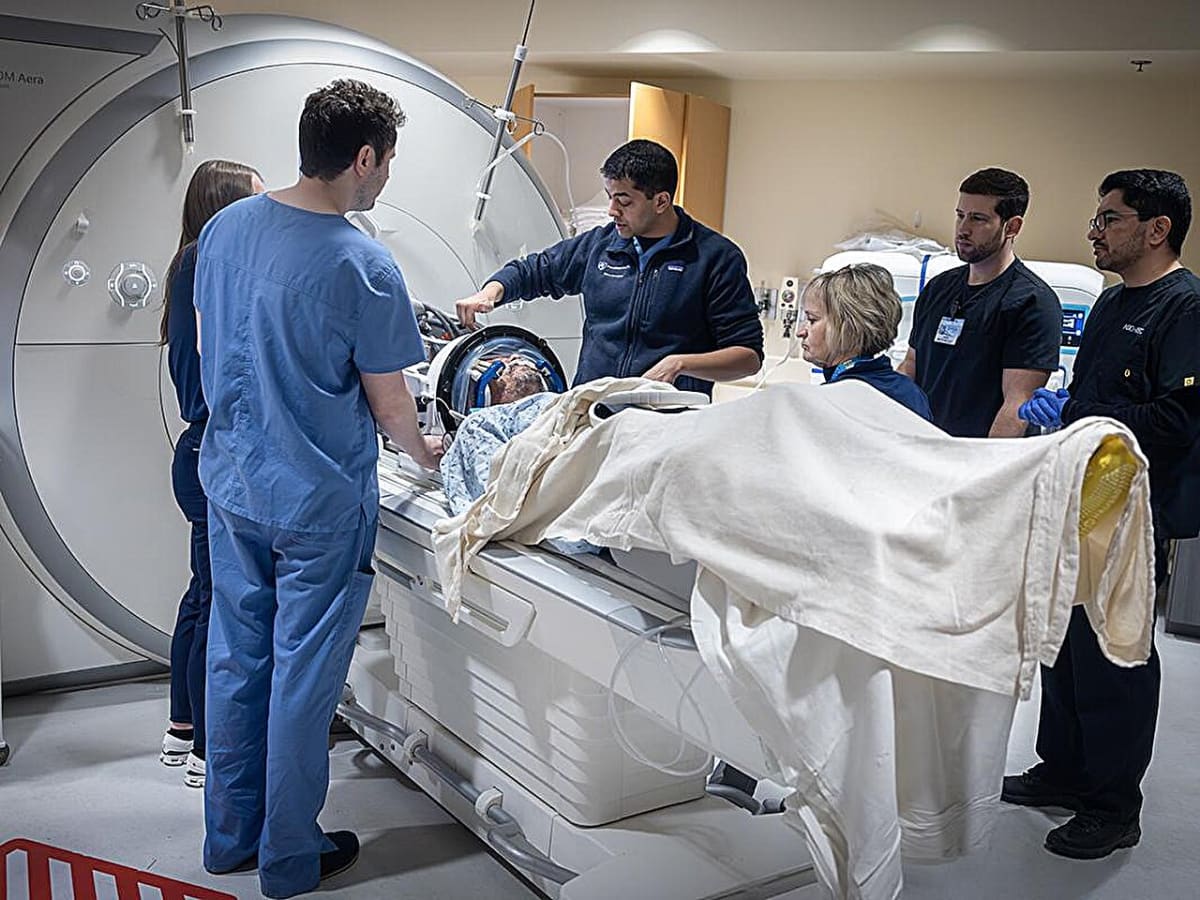 Doctor preparing patient for focused ultrasound treatment targeting essential tremor in medical facility